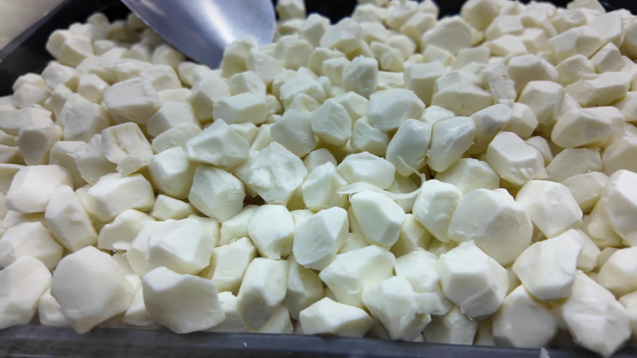 Grains de caillé de mozzarella frais dans un plateau de présentation