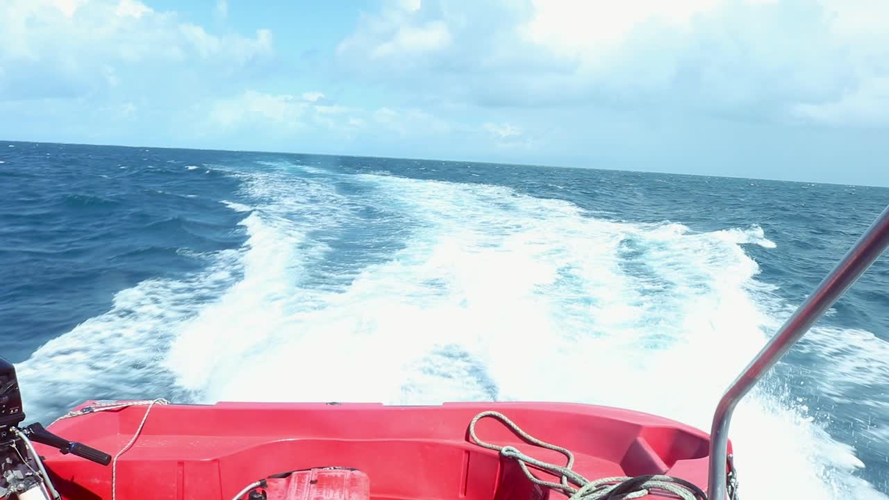 Boat speeds through the ocean and leaves a long turbulent wake.
