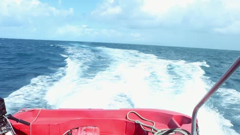 boat speeds through the ocean and leaves a long turbulent wake.