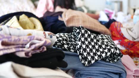 woman folding and organizing a pile of clothes