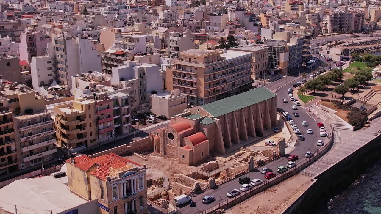 Vista aerea di una città costiera con chiesa storica e traffico