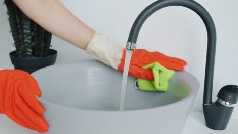 cleaning a sink with gloves