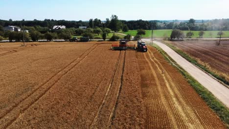 Toma-Aérea-De-La-Cosechadora-Cargando-Granos-De-Maíz-En-El-Remolque-Del-Tractor