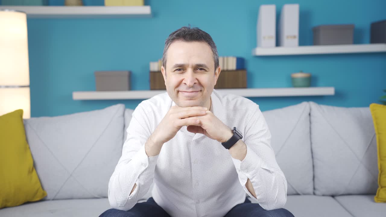 el hombre que mira a la cámara sonríe.