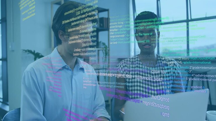 Coworkers sitting at desk and initiating software debugging on laptop with code overlay shifting