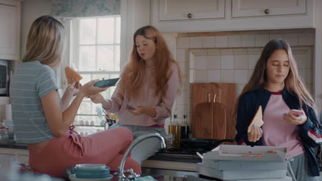 group-of-teenage-girls-eating-pizza-in-kitchen-having-fun-chatting-together-using-smartphones-sharing-lifestyle-friends-hanging-out-enjoying-relaxing-at-home