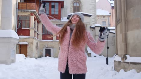 mujer viajera en la ciudad de invierno leyendo en línea sms teléfono móvil ganando premios, bailando, celebrando