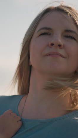 primer plano de una mujer con un vestido azul llevando a su hijo pequeño, que lleva una camiseta blanca. el niño parece triste mientras la mujer mueve suavemente el cabello de su cara