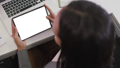 mujer de negocios biracial que usa una tableta para videollamadas con espacio para copiar