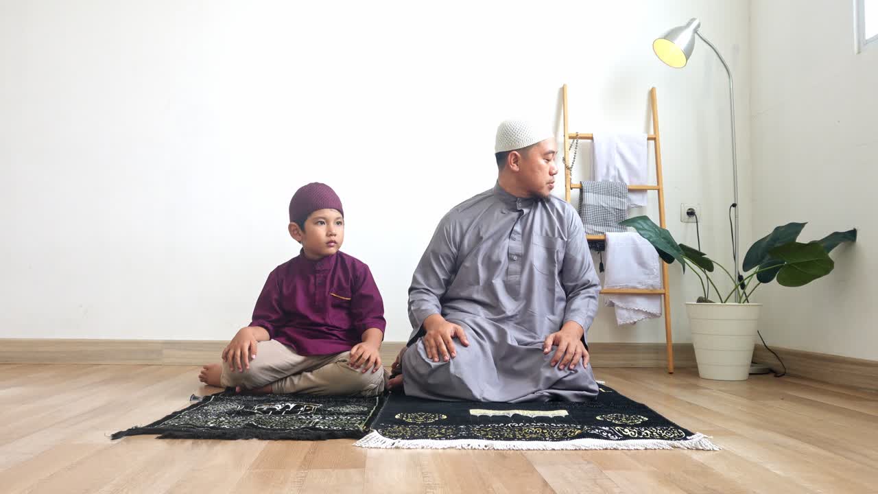 Father And Son Praying Salah Together On Mats At Home Demonstrating Islamic Devotion And Faith