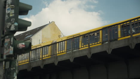 tren u-bahn amarillo que pasa por un puente industrial en berlín, alemania