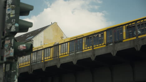 żółty pociąg u-bahn przejeżdżający przez most przemysłowy w berlinie, niemcy