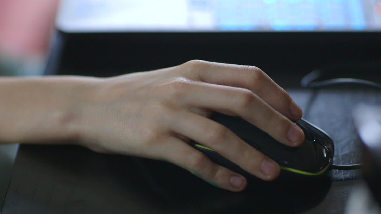 Closeup of a young boy's hand on a computer mouse