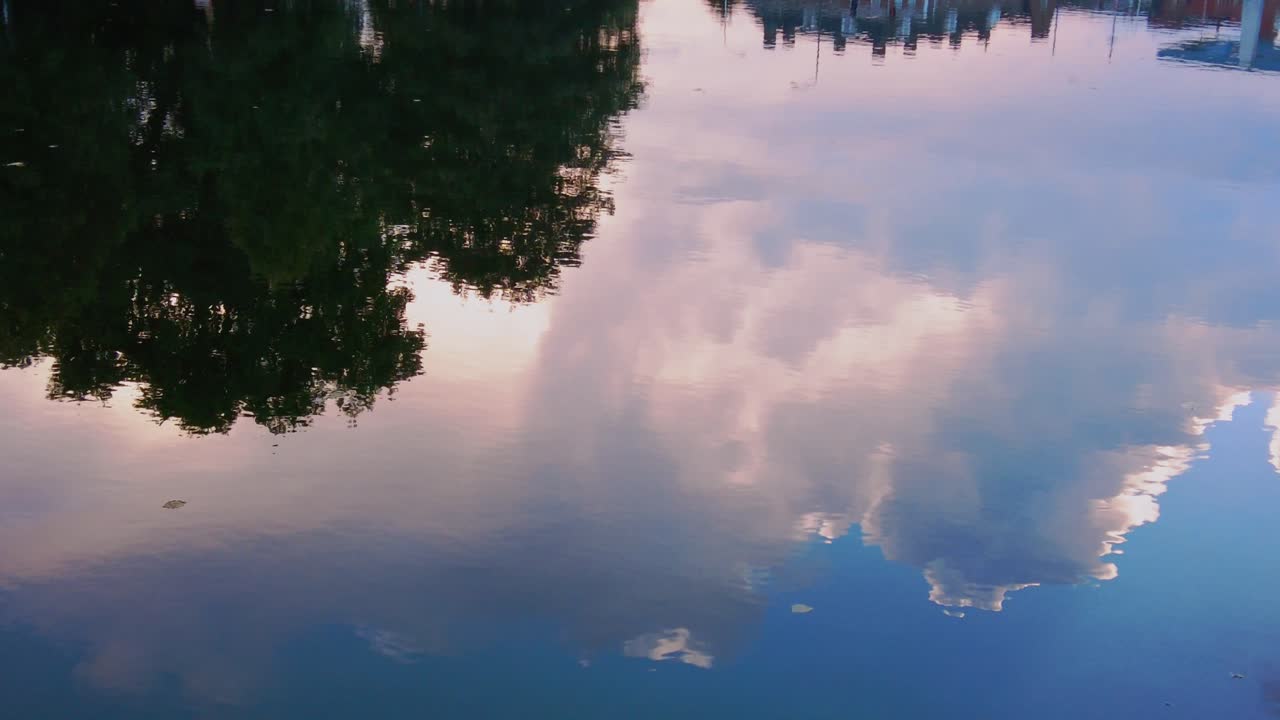 Peaceful reflection of clouds in still water in netherlands during golden hour