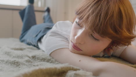 close up view of thoughtful girl lying on the bed moving her legs