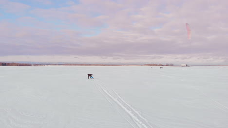 kitesurfista siendo arrastrado por su cometa a través de la nieve