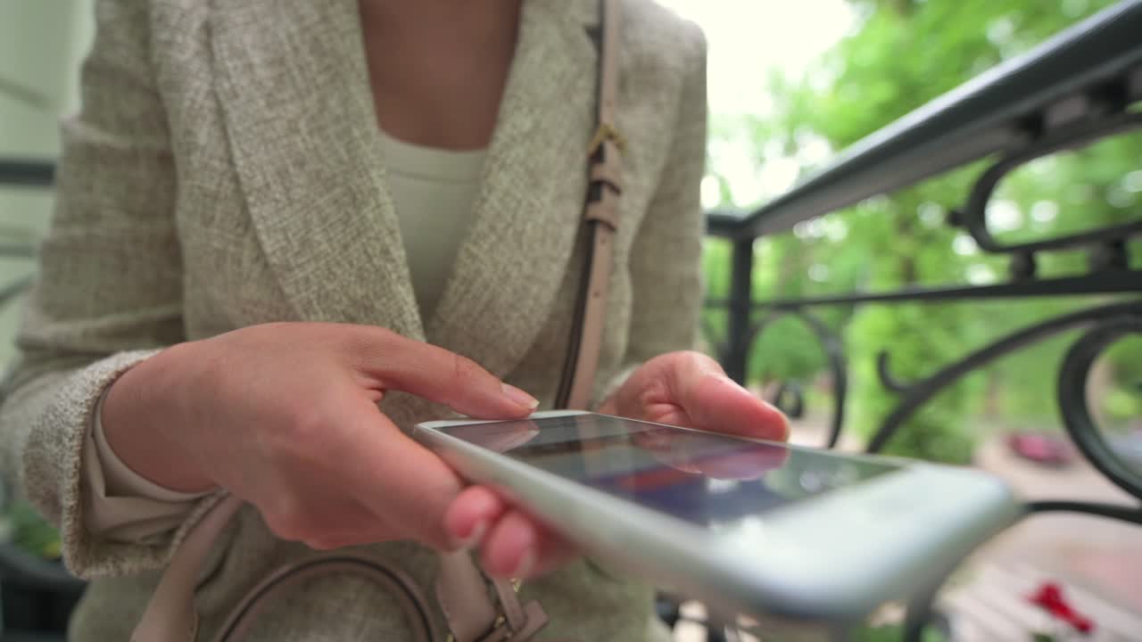 Close up of a woman scrolling on her phone at a terrace
