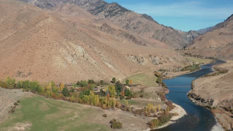 Drone-footage-of-a-remote-landing-strip,-bridge-over-a-river,-and-camp-surrounded-by-mouintains-and-a-river-in-the-Frank-Church-River-of-No-Return-Wilderness-in-Idaho