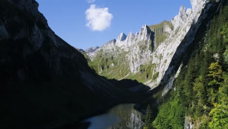 aerial-drone-flight-through-mountain-valley-with-reflecting-lake-in-switzerland