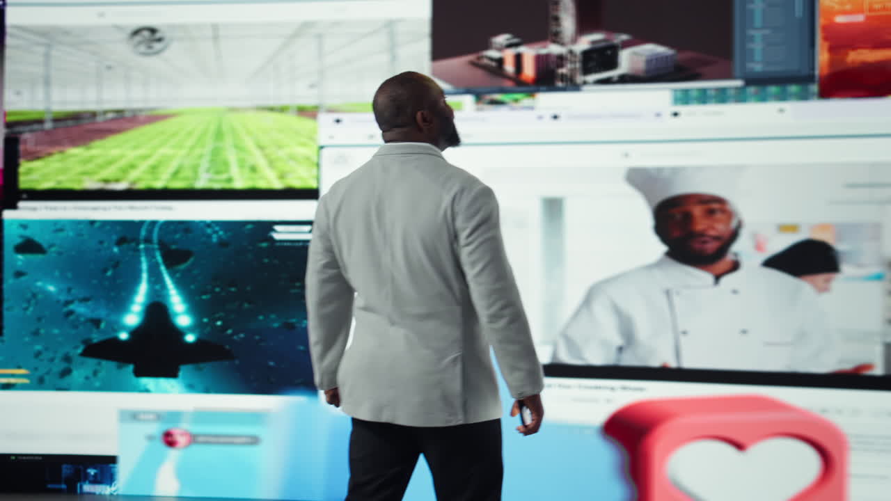 Man browsing social media feed on smartphone in front of digital video wall