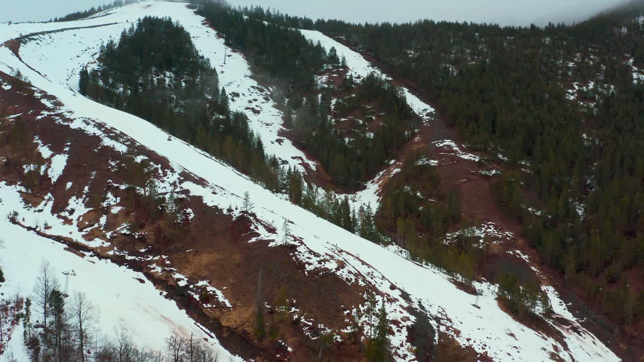 toma aérea sobrevolando la ladera de una montaña cubierta de nieve