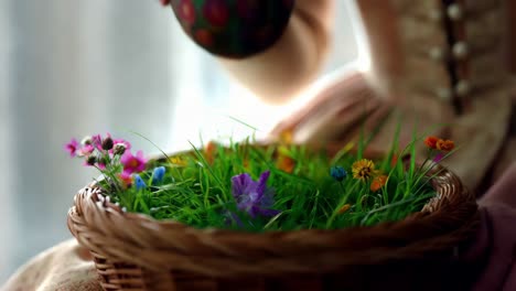 woman holding decorated easter egg in a basket