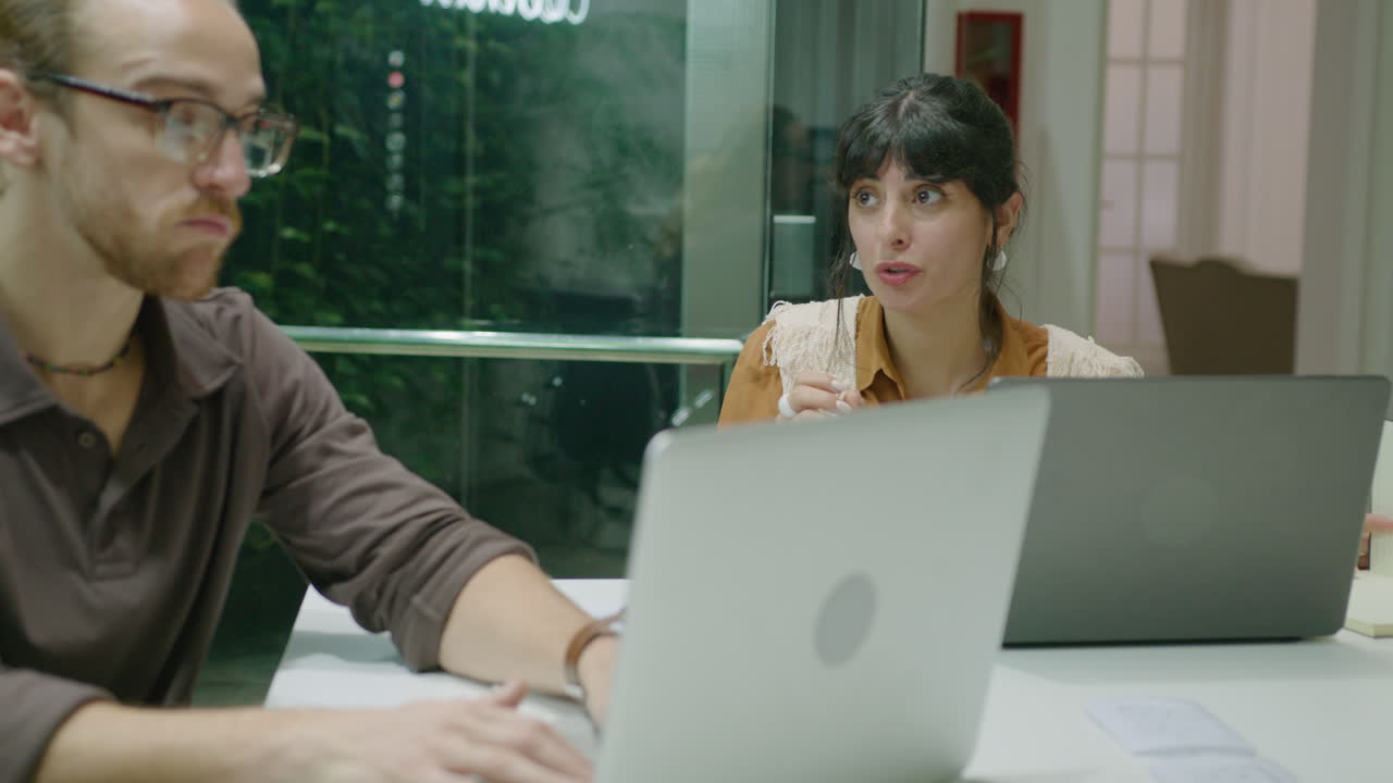 Two Colleagues Working Together and Discussing Job in the Office