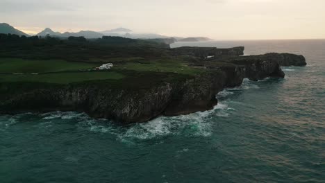 coastal cliffs of asturias, spain with rugged terrain and ocean waves at dusk, serene landscape