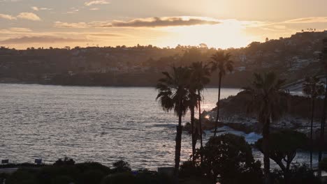 la jolla cove drone wschód słońca poziomy ruch od prawej do lewej z efektem paralaksy na pobliskie palmy