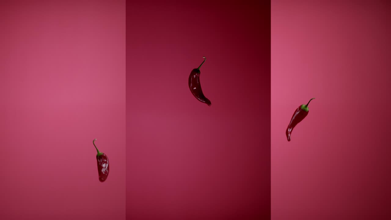 신선한 매운 칠리 고추가 날아다니며 공중에 매달려 떨어집니다.