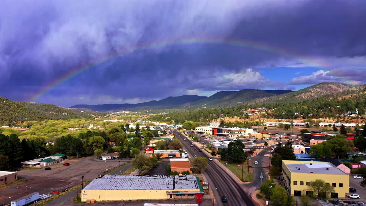 un gran arco iris sobre una ciudad y un camino a través de ella