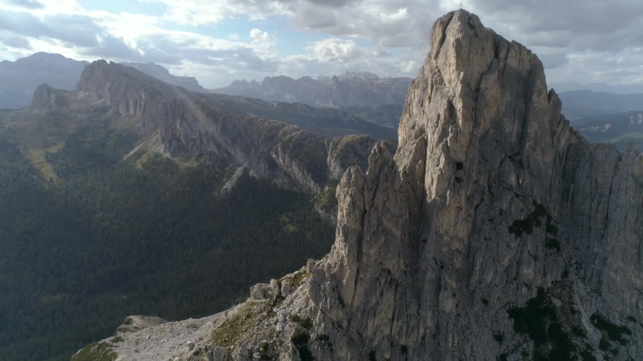 Vista aerea ravvicinata a una cima nelle Dolomiti italiane che rivela altro sullo sfondo durante il tramonto.
