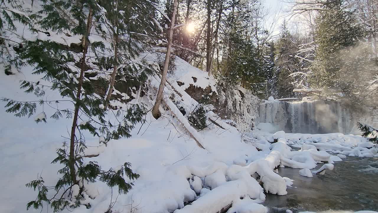 Ujęcie panoramiczne pięknych, płynących wodospadów Hogs Falls, pokrytych warstwą białego śniegu i lodu w zimowy poranek, Ontario, Kanada