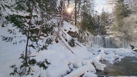 an establishing pan shot of the beautiful flowing hogs falls covered in a layer of white snow and ice on a winter’s morning, ontario, canada