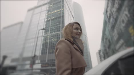 woman walking in a city with skyscrapers