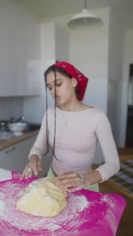 teenage girl kneading dough in the kitchen
