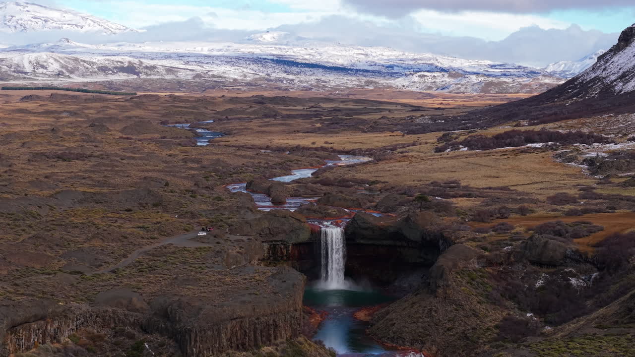 Salto del Agrio waterfall in a vast valley with snowy mountains in Argentina, Aerial
