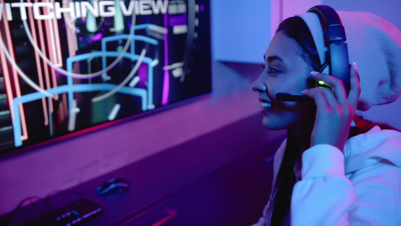 Gaming enthusiast wearing headset, smiling while playing video game on computer, copy space