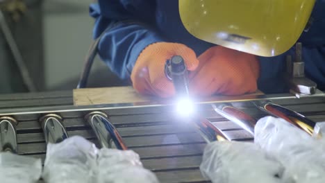 man wearing mask welding in a workshop. metal workers use manual labor. skilled welder. welder is welding the stainless steel pipes in the factory. welder industrial part in factory.