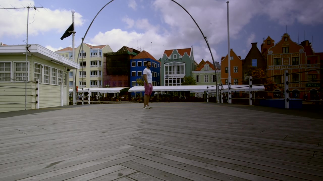 Turist over den åbnende Dronning Emma Bro. Willemstad, Curaçao. Rejse. Turisme i Sint Anna Bugten. Hollandsk arkitektur.