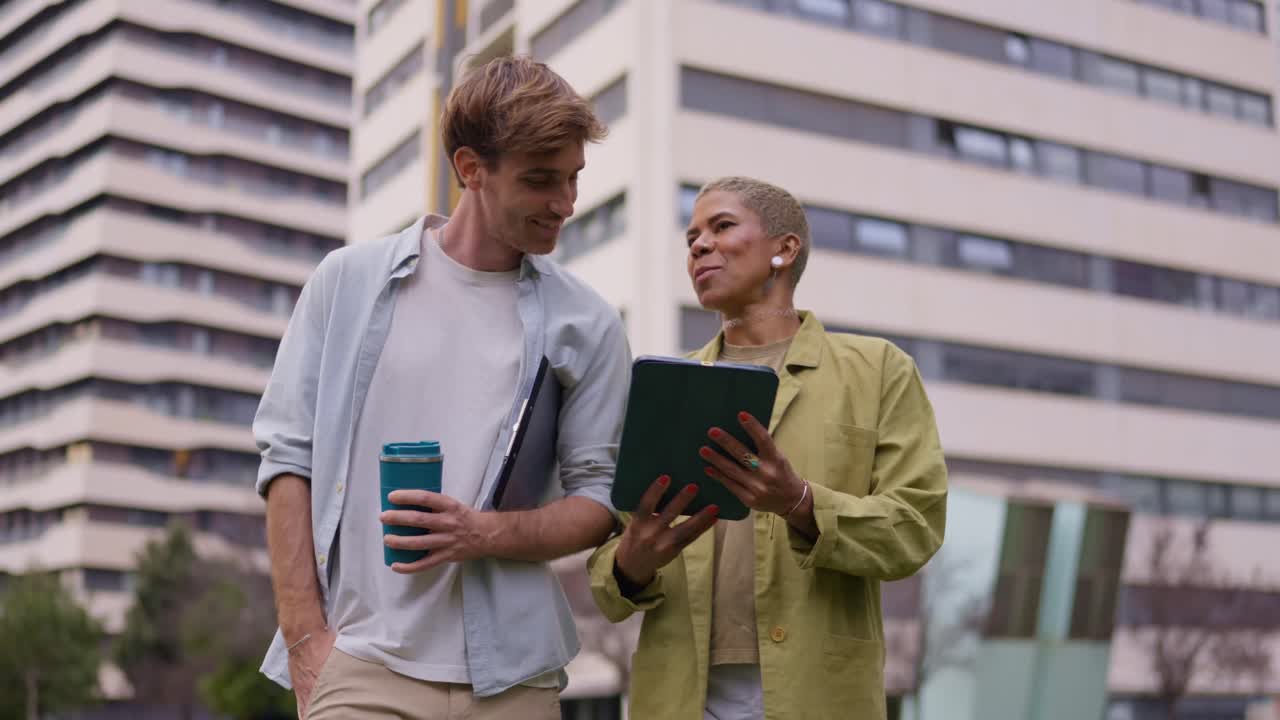 Two colleagues walking and discussing work outdoors