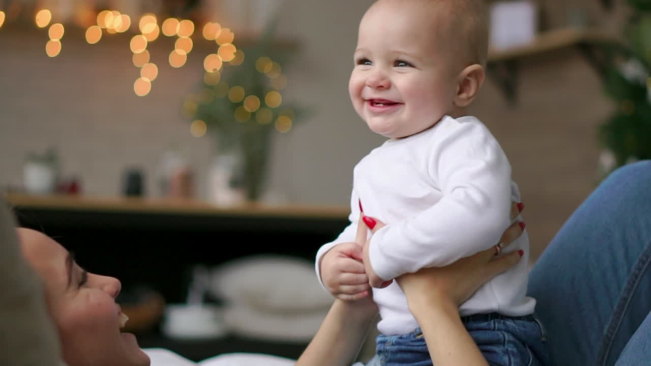 어린 엄마 는 침대 에서 아기 소년 과 함께 놀고 있다