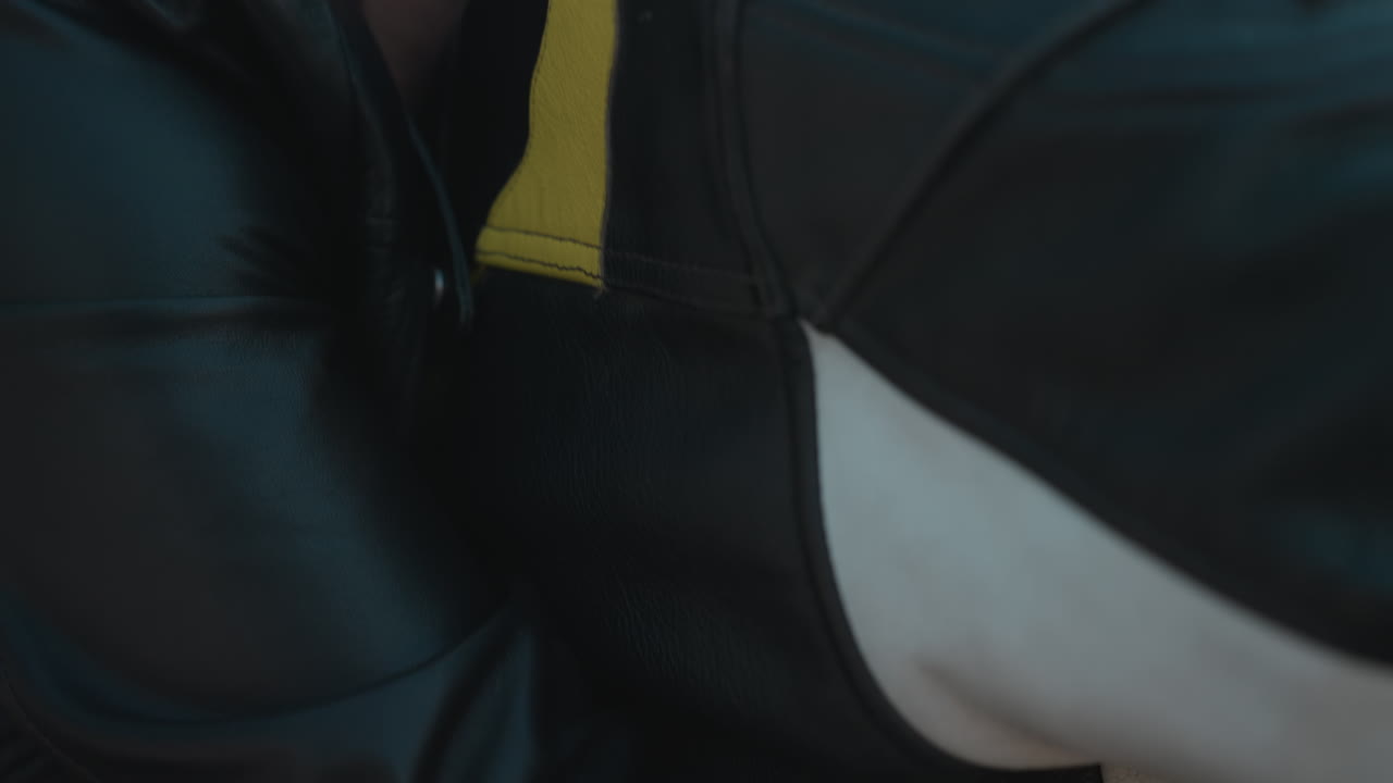 Woman wearing sunglasses holds rider warmly from behind while smiling, sunlight creating natural lens flare on motorcycle ride scene with strong sense of closeness, connection, and outdoor freedom