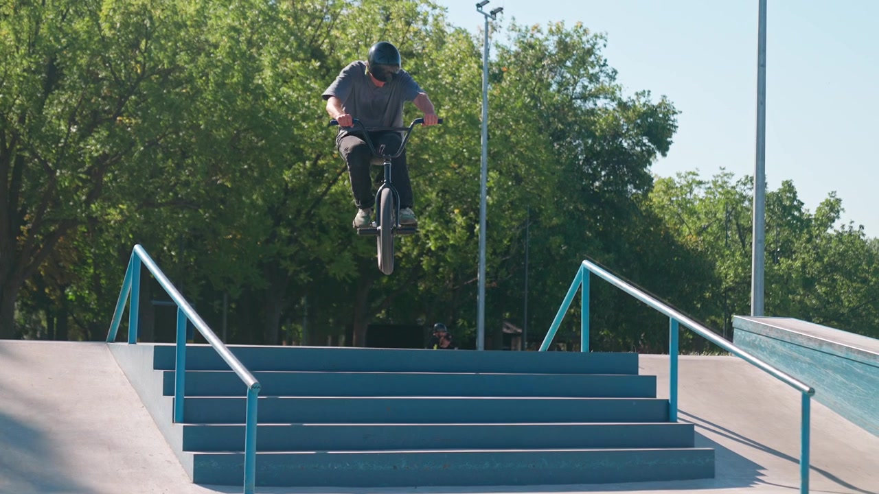 Ciclista BMX che salta giù dalle scale di cemento in uno skatepark