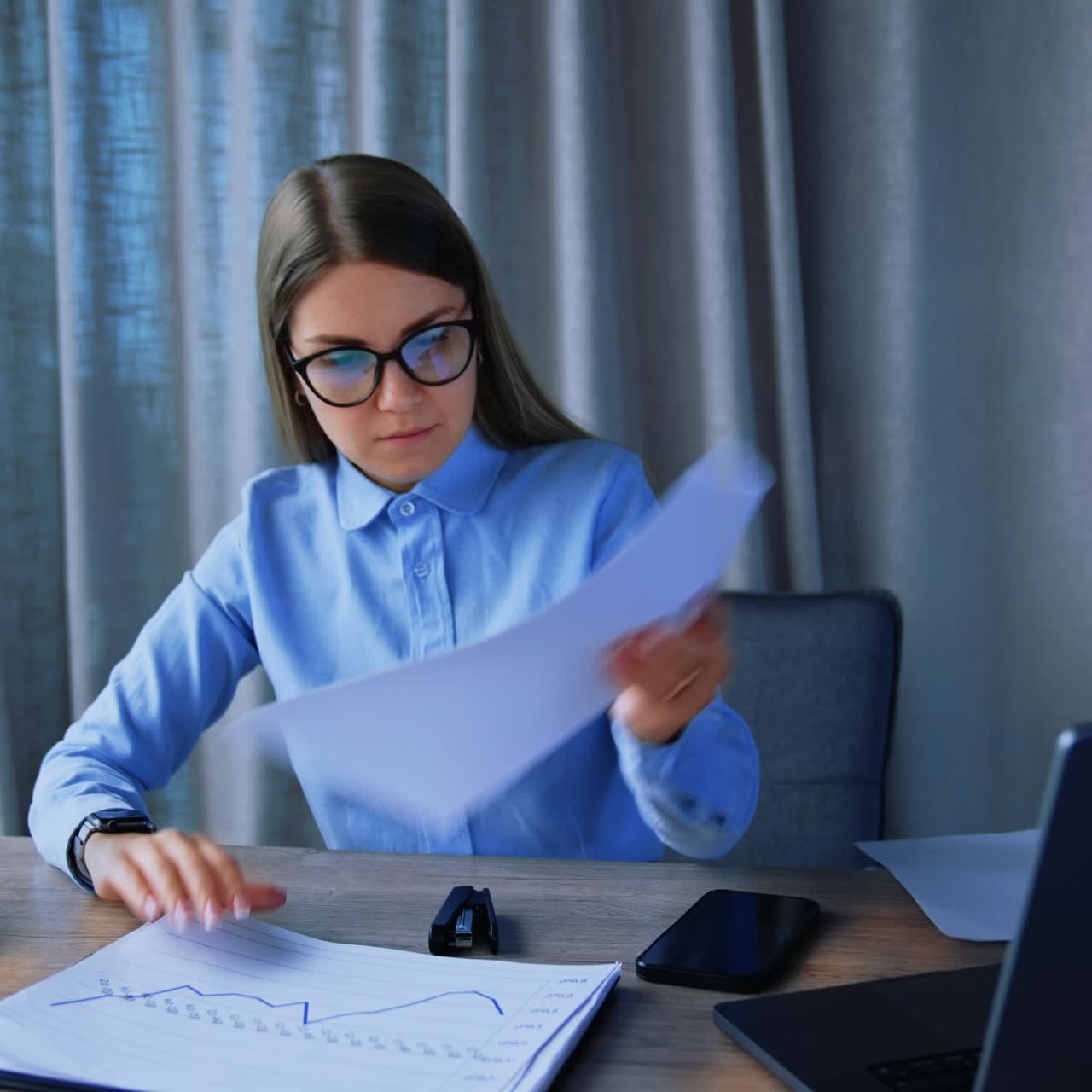Blonde woman looking for a necessary document turning the pages. Busy business lady at work in the office