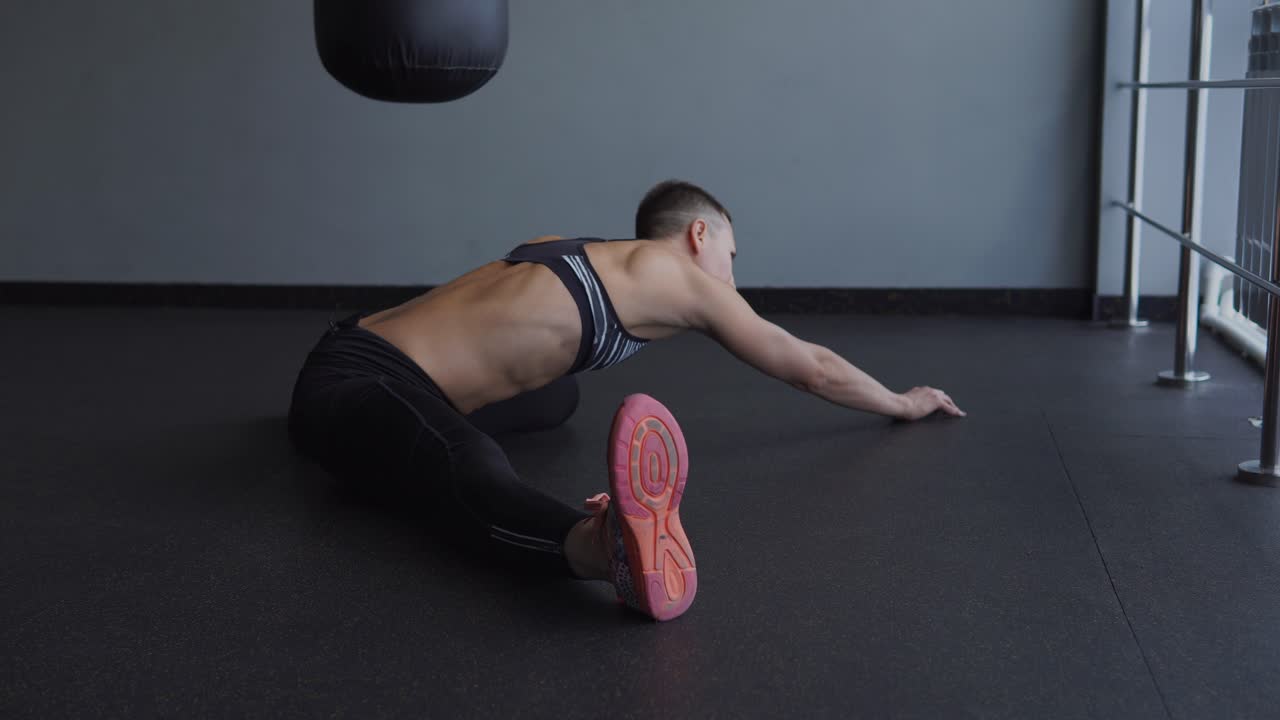 mujer estirándose en un gimnasio