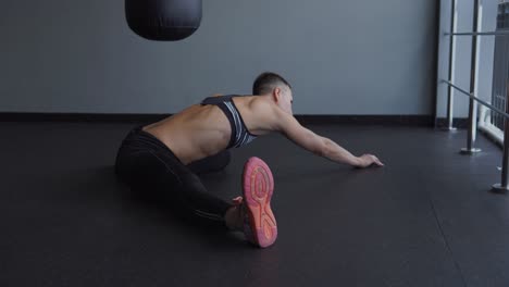 mujer estirándose en un gimnasio