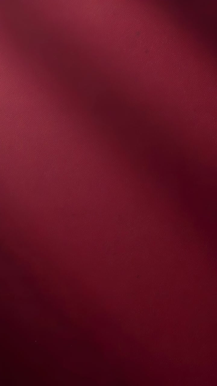 Vertical video: Showing maroon drape shifting during focus shift in closeup with diagonal bands