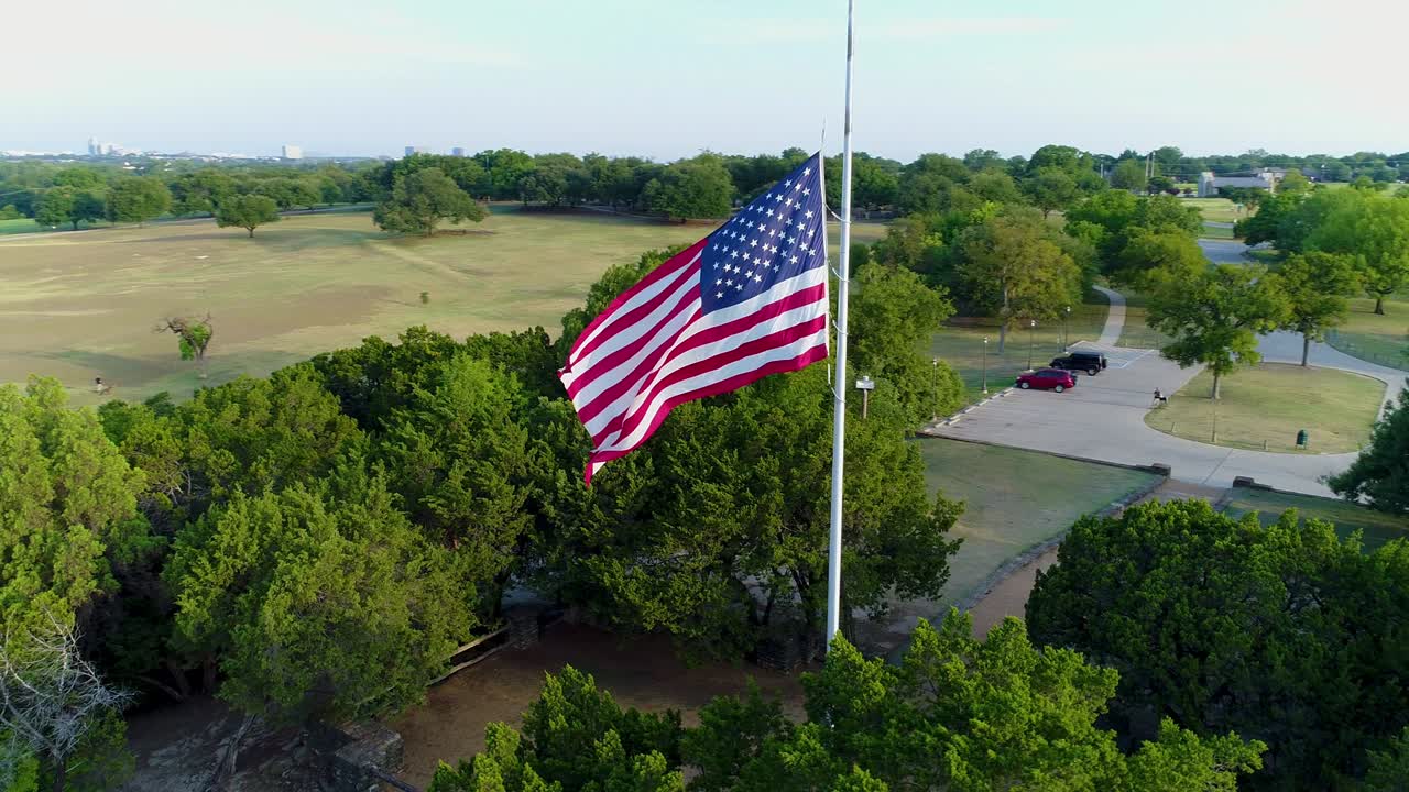 vista de avión no tripulado de la bandera de estados unidos a mitad de asta, volando alrededor de la bandera en sentido contrario a las agujas del reloj