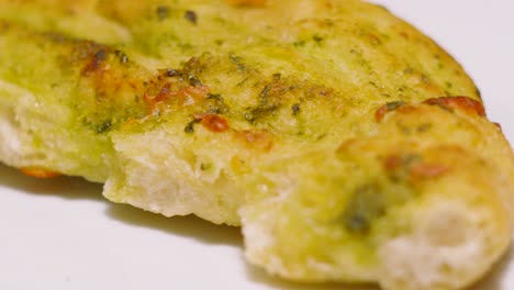 slow moving shot over freshly baked mozzarella and tomato pesto garlic bread. fresh italian side dish food